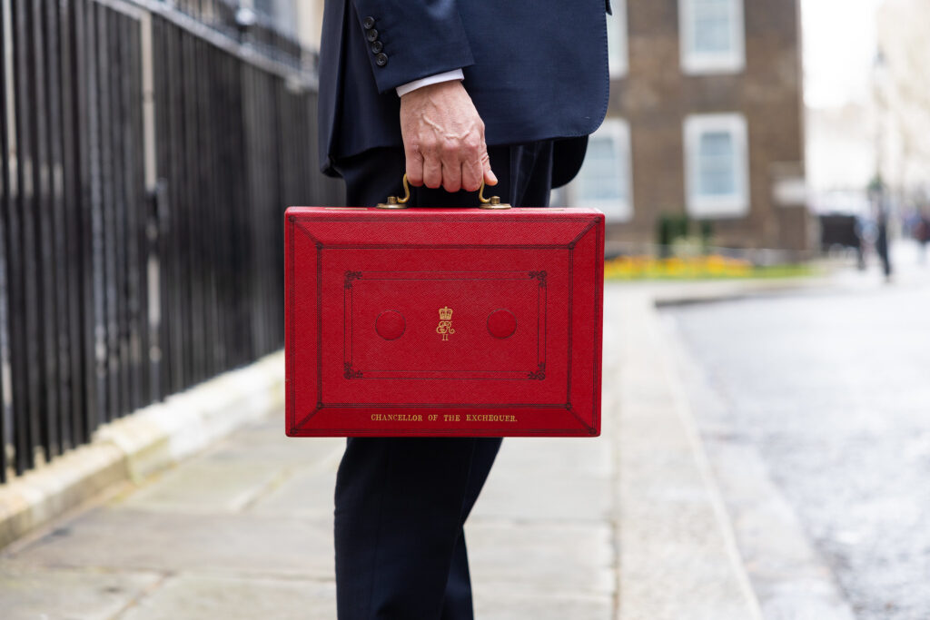 The Chancellor of the Exchequer holds the red box in Downing Street.